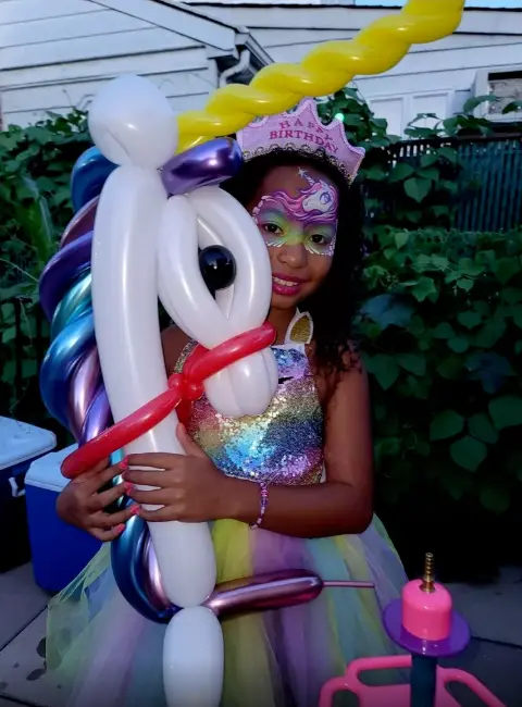 Child holding a colorful balloon animal