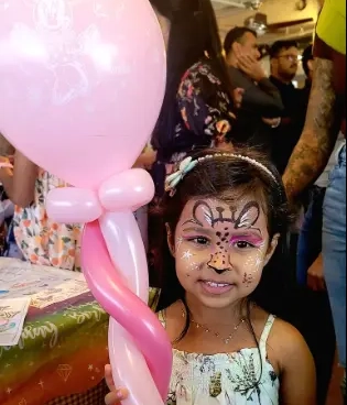 Kids with face paint holding balloon animals